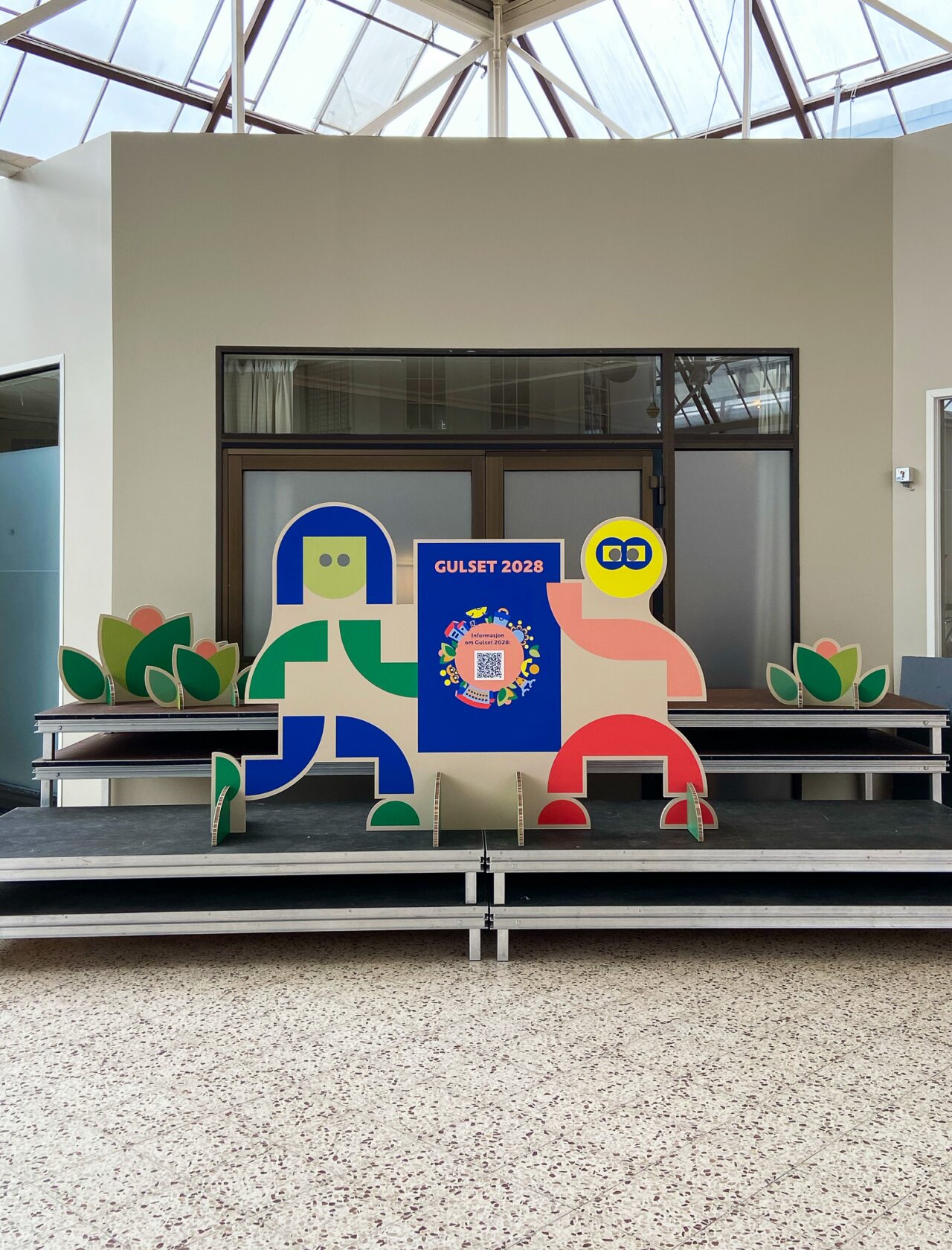 Utskårne grafiske figurer på en scene.