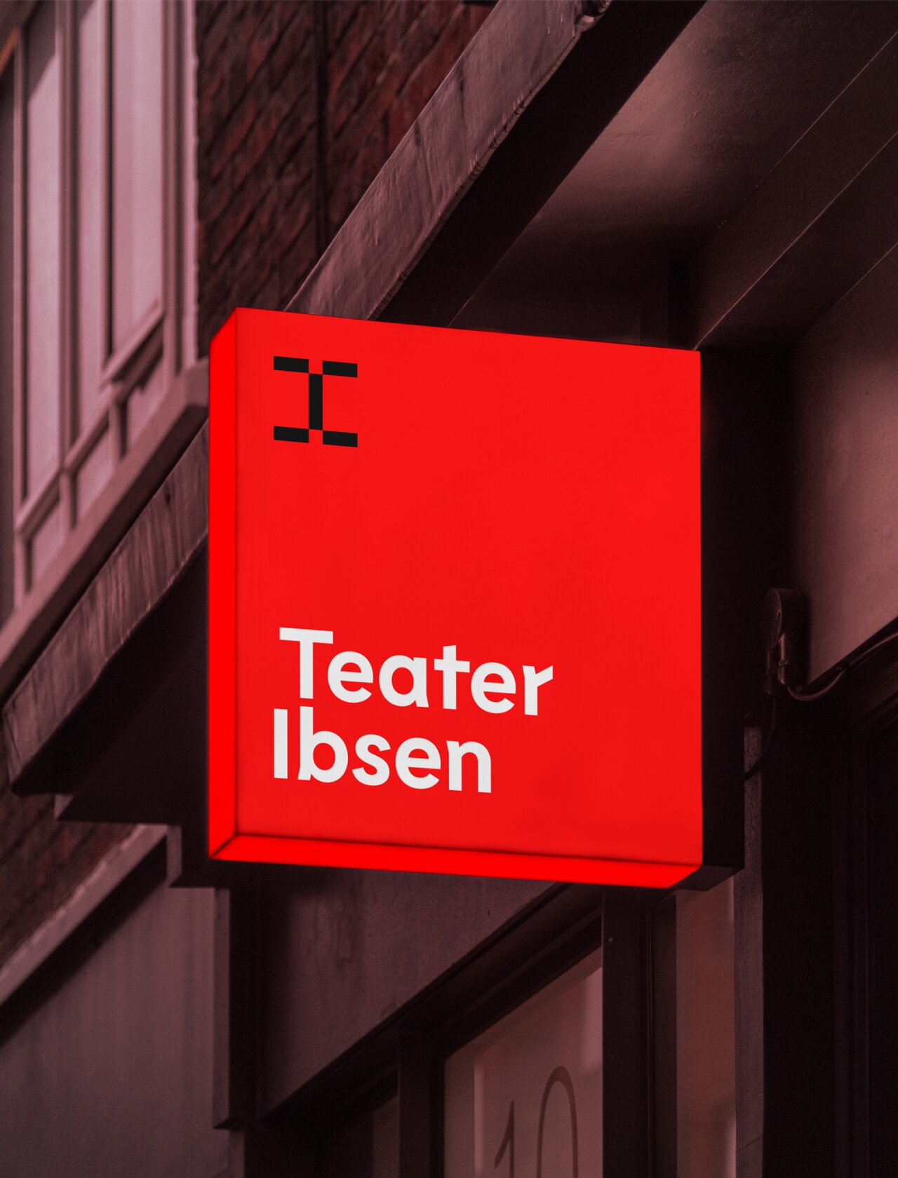 Rødt skilt utenfor bygning med Teater Ibsen logo